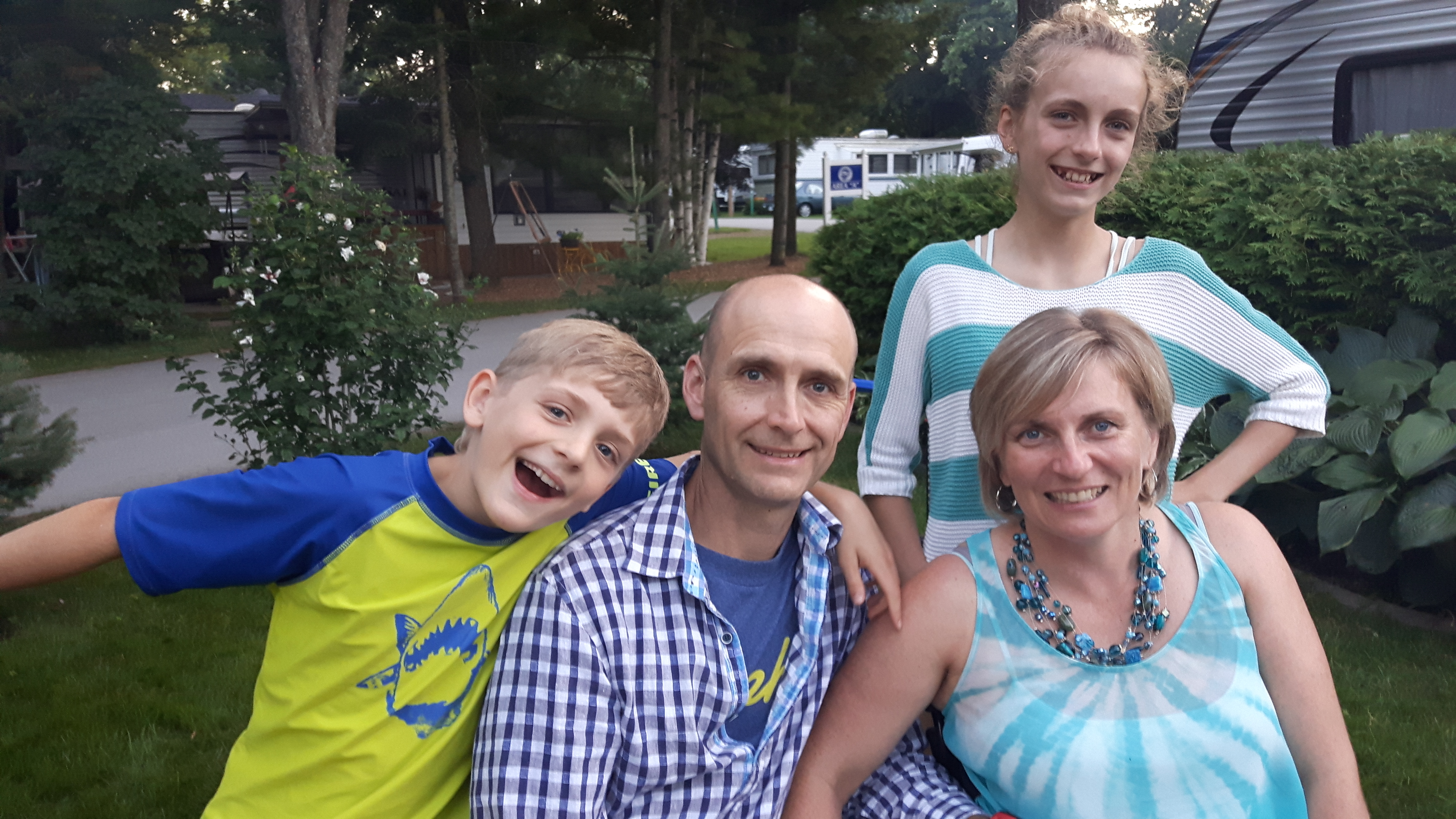 Family in backyard all smiling, two young children with Julie and her husband